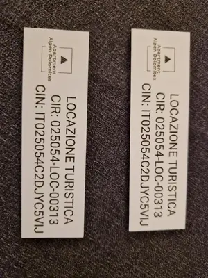 two white tags with text on them on a table at Apartment Alpen Dolomites in Selva di Cadore