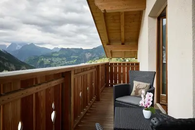 a balcony with a chair and a view of mountains at Apartment Alpen Dolomites in Selva di Cadore