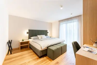 a bedroom with a bed with a green headboard at Villa Julia in Lana