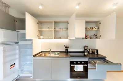 a kitchen with white cabinets and a sink at Villa Julia in Lana