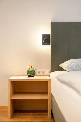 a nightstand with a plant on it next to a bed at Villa Julia in Lana