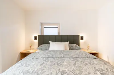 a bedroom with a large bed and two night stands at Villa Julia in Lana