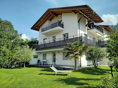 a white house with a bench in the yard at Ferienwohnungen HÖLLERHOF in Terlan in Vilpiano
