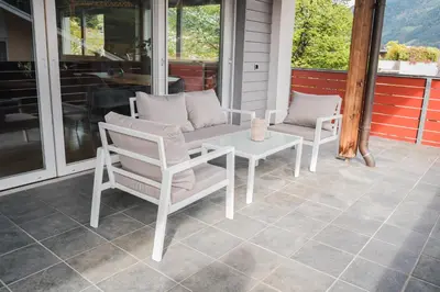 a patio with a table and chairs on a porch at Penthouse Ferienwohnung- 3 Schlafzimmer in Naturno