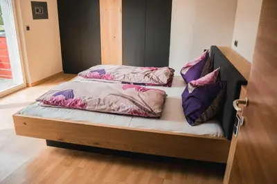 a bed with three pillows on top of it at Penthouse Ferienwohnung- 3 Schlafzimmer in Naturno
