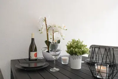 a table with a bottle of wine and a glass at Jacuzzi Suite Appartement bei Meran in Merano