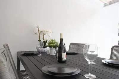 a dining table with a bottle of wine and glasses at Jacuzzi Suite Appartement bei Meran in Merano