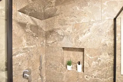 a bathroom with a shower with two plants in it at Jacuzzi Suite Appartement bei Meran in Merano
