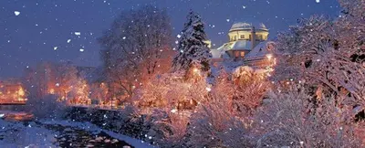 a building at night with snow on the trees at Jacuzzi Suite Appartement bei Meran in Merano