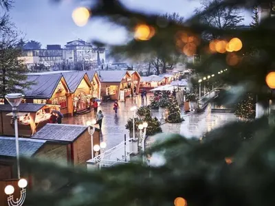 a town with christmas trees and lights in the rain at Jacuzzi Suite Appartement bei Meran in Merano