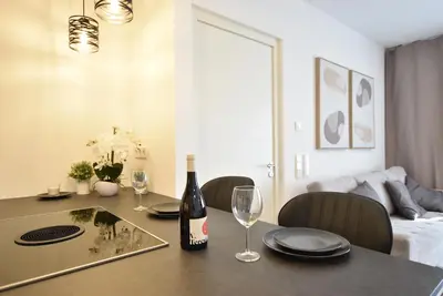a dining room table with a bottle of wine and glasses at Jacuzzi Suite Appartement bei Meran in Merano
