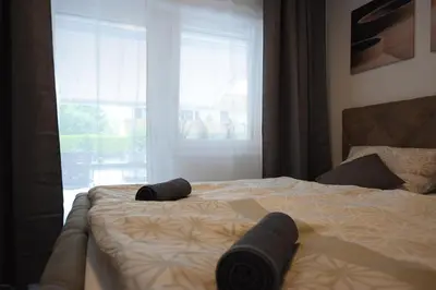 a bed with two black towels on it with a window at Jacuzzi Suite Appartement bei Meran in Merano