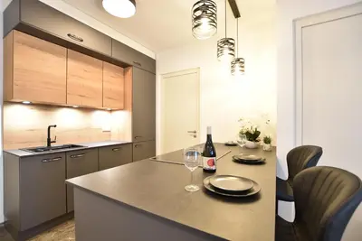a kitchen with a table with two glasses of wine at Jacuzzi Suite Appartement bei Meran in Merano