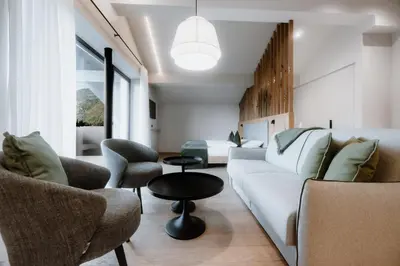 a living room with a white couch and chairs at Stricker Aparthotel in Tirolo