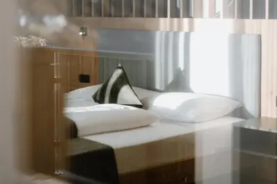 a room with a bed with two pillows at Stricker Aparthotel in Tirolo