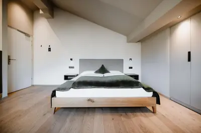 a bedroom with a large bed in a room at Stricker Aparthotel in Tirolo