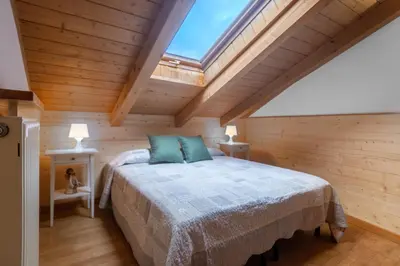 a bedroom with a bed and a skylight at DolomiApartments - Appartamento Fiordaliso in Predazzo
