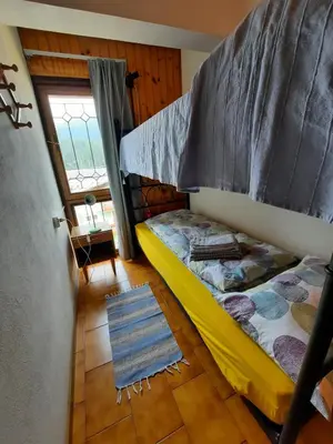 a bedroom with a bunk bed and a window at Appartamento Fiorella in San Martino di Castrozza