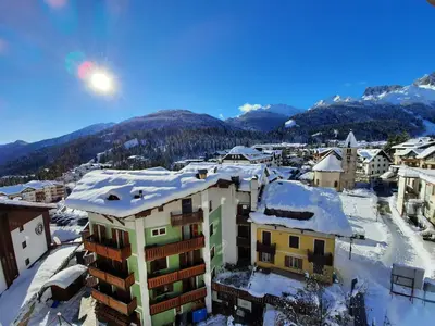 a city with snow on the roofs of buildings at Appartamento Fiorella in San Martino di Castrozza
