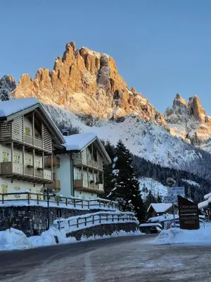 a lodge in the mountains with snow on the ground at Appartamento Fiorella in San Martino di Castrozza