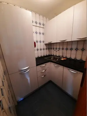 a small kitchen with white cabinets and a sink at Appartamento Fiorella in San Martino di Castrozza