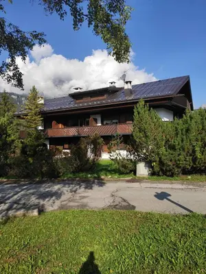 a house with a solar roof on top of it at Villa 5 Torri in Cortina dʼAmpezzo