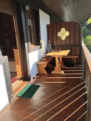 a porch with a bench and a table on a house at Villa 5 Torri in Cortina dʼAmpezzo