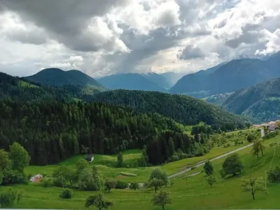 a green valley with a road in the mountains at Eggernhof in Lauregno