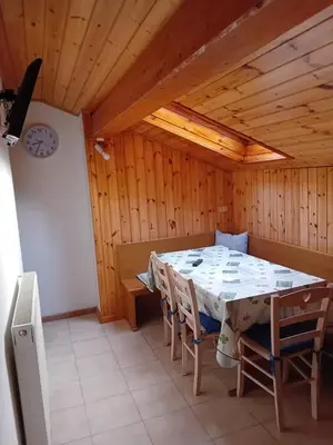 a dining room with a table and chairs and a clock at Eggernhof in Lauregno