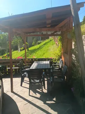a patio with a table and chairs under a pergola at Eggernhof in Lauregno