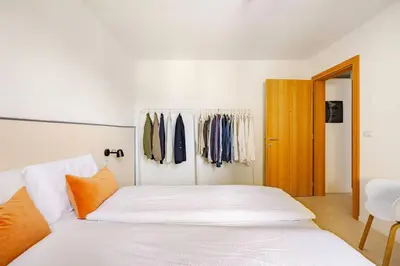 a bedroom with a white bed and a closet at Casa Pradiei Dolomiti View in Cavareno