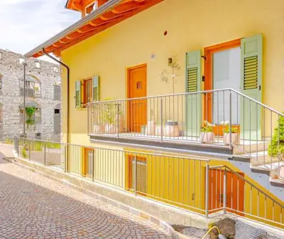 a yellow building with balconies on a street at Casa Pradiei Dolomiti View in Cavareno