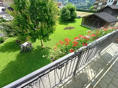 a balcony with a garden with flowers and a tree at Una vacanza in Trentino da ricordare in Mezzano