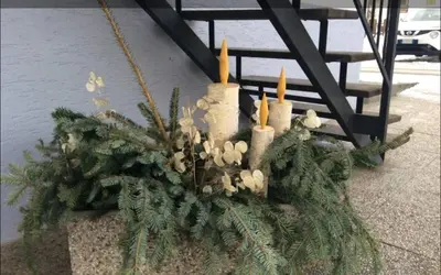 a christmas centerpiece with candles and christmas trees at Una vacanza in Trentino da ricordare in Mezzano