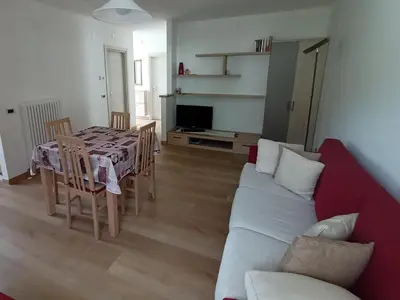 a living room with a couch and a table with chairs at Una vacanza in Trentino da ricordare in Mezzano