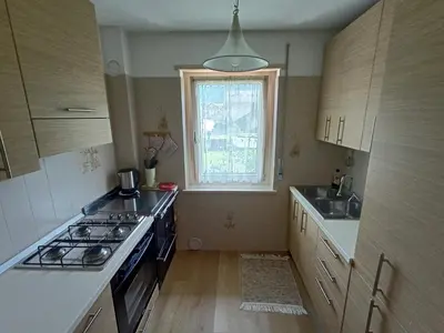 a kitchen with a stove and a sink and a window at Una vacanza in Trentino da ricordare in Mezzano