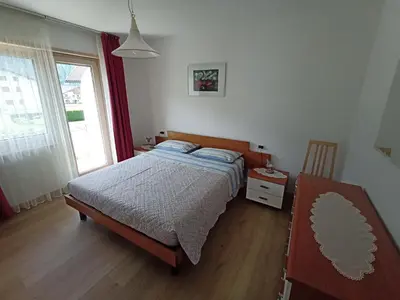 a bedroom with a bed and a window at Una vacanza in Trentino da ricordare in Mezzano