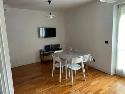 a dining room with a table and chairs and a television at A casa di Cato in Merano