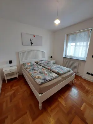 a bedroom with a bed and a wooden floor at A casa di Cato in Merano