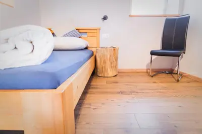 a bed with a blue mattress and a chair in a room at Oberkrösserhof in San Lorenzo di Sebato