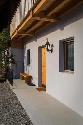 a house with a wooden door and a wooden bench at Oberkrösserhof in San Lorenzo di Sebato
