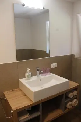 a bathroom sink with a large mirror above it at Oberkrösserhof in San Lorenzo di Sebato