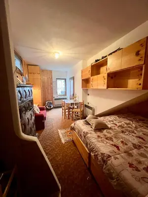 a bedroom with a bed and a dining room at Ciasa AGB in Moena