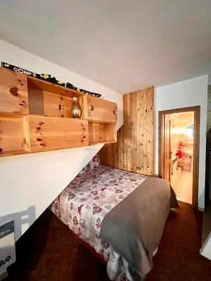 a bedroom with a bed and wooden cabinets at Ciasa AGB in Moena