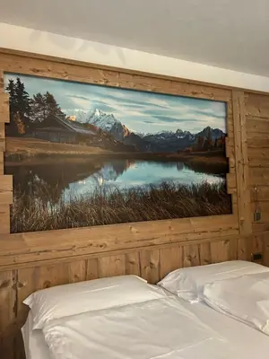a bedroom with a large painting of a lake at EL CIASEL in Canazei
