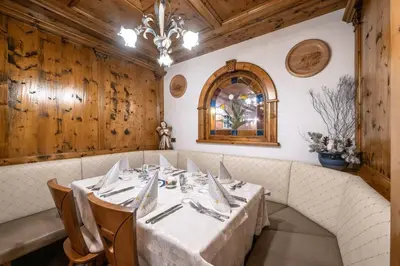 a dining room with a table and a chandelier at EL CIASEL in Canazei
