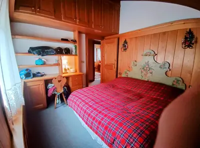 a bedroom with a bed with a red plaid blanket at San vito di Cadore centro - Cortina D'ampezzo in San Vito di Cadore