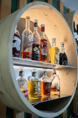 a shelf filled with lots of bottles of alcohol at Berghotel Zorzi in Alpe di Siusi