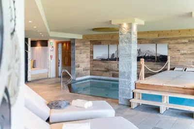 a living room with a tub and a couch at Berghotel Zorzi in Alpe di Siusi