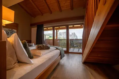 a bedroom with a bed with a view of a mountain at Berghotel Zorzi in Alpe di Siusi